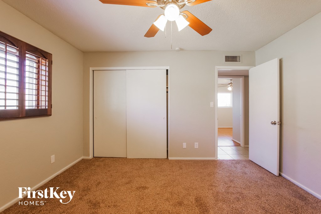 the master bedroom with carpeted flooring and a ceiling fan