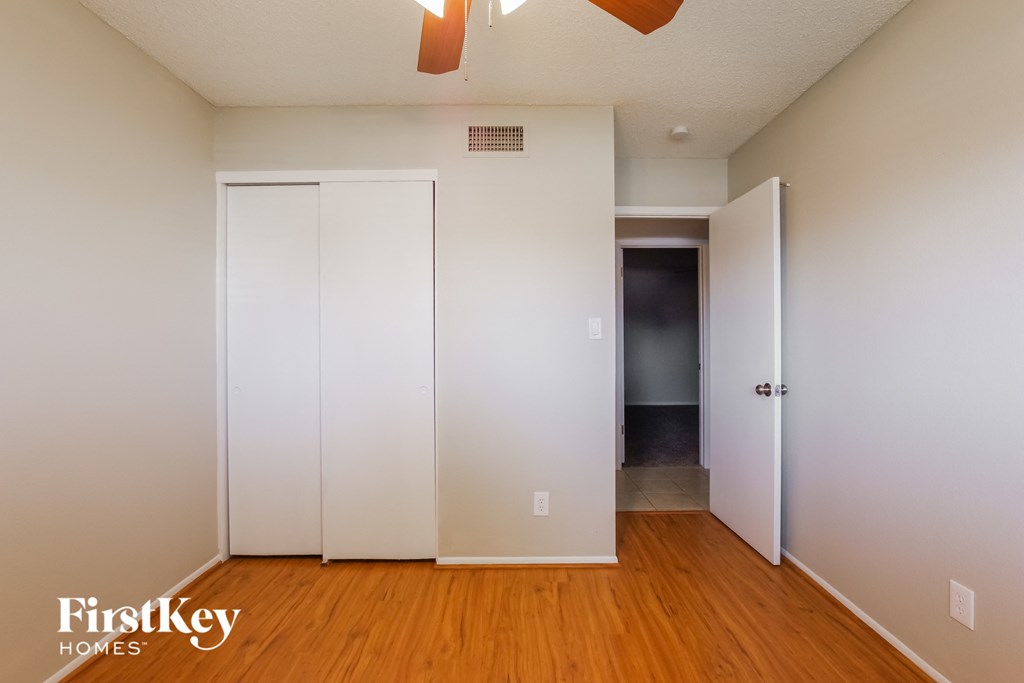 the closets in the master bedroom of a home with wood floors and white walls