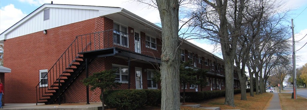 A red brick building with a black metal staircase.