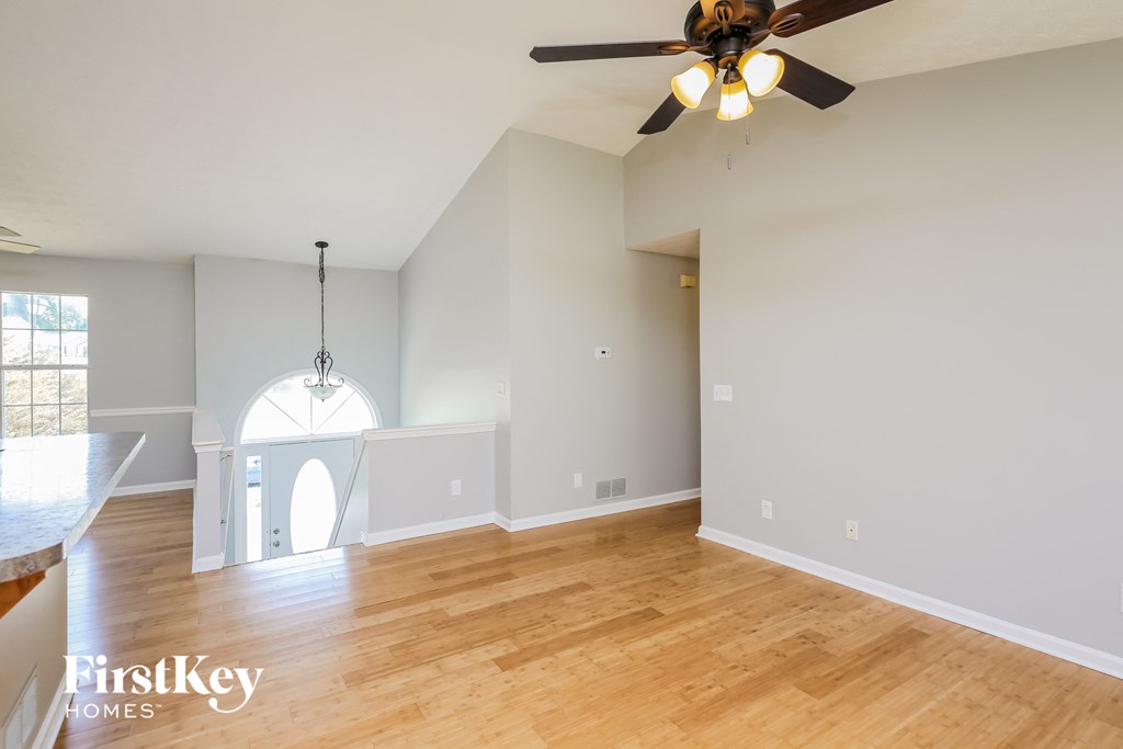 a living room with a ceiling fan and a wooden floor