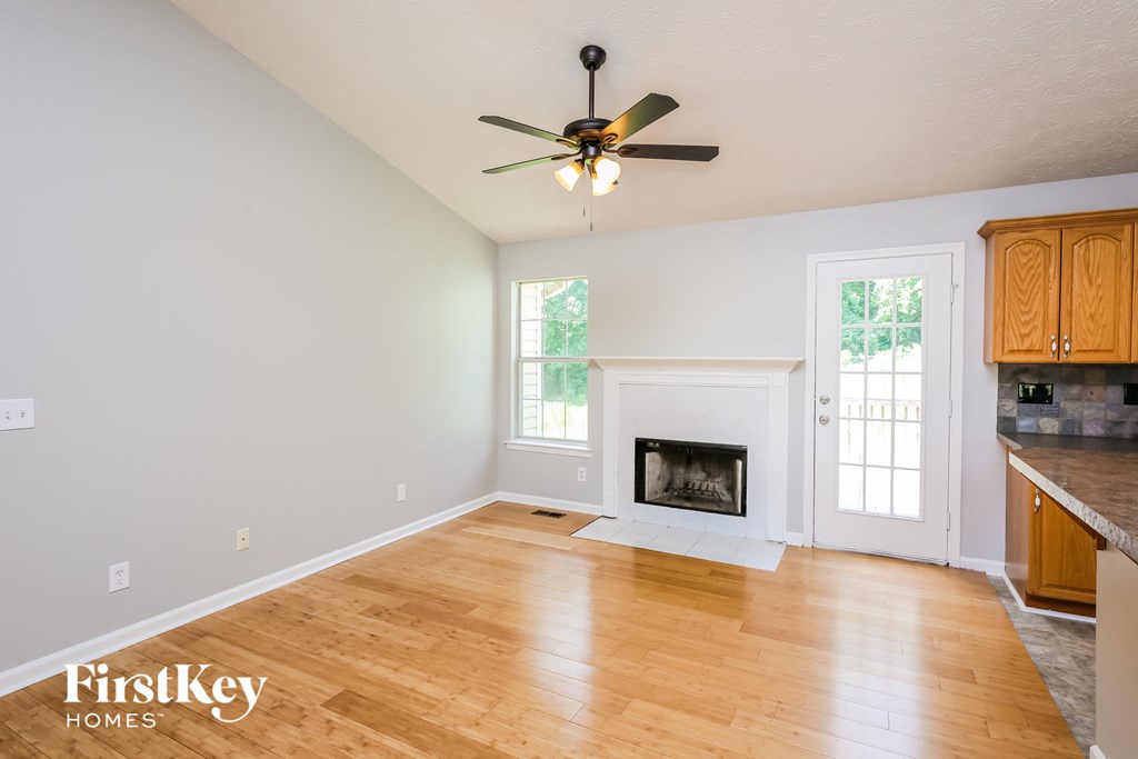 a living room with a fireplace and a ceiling fan