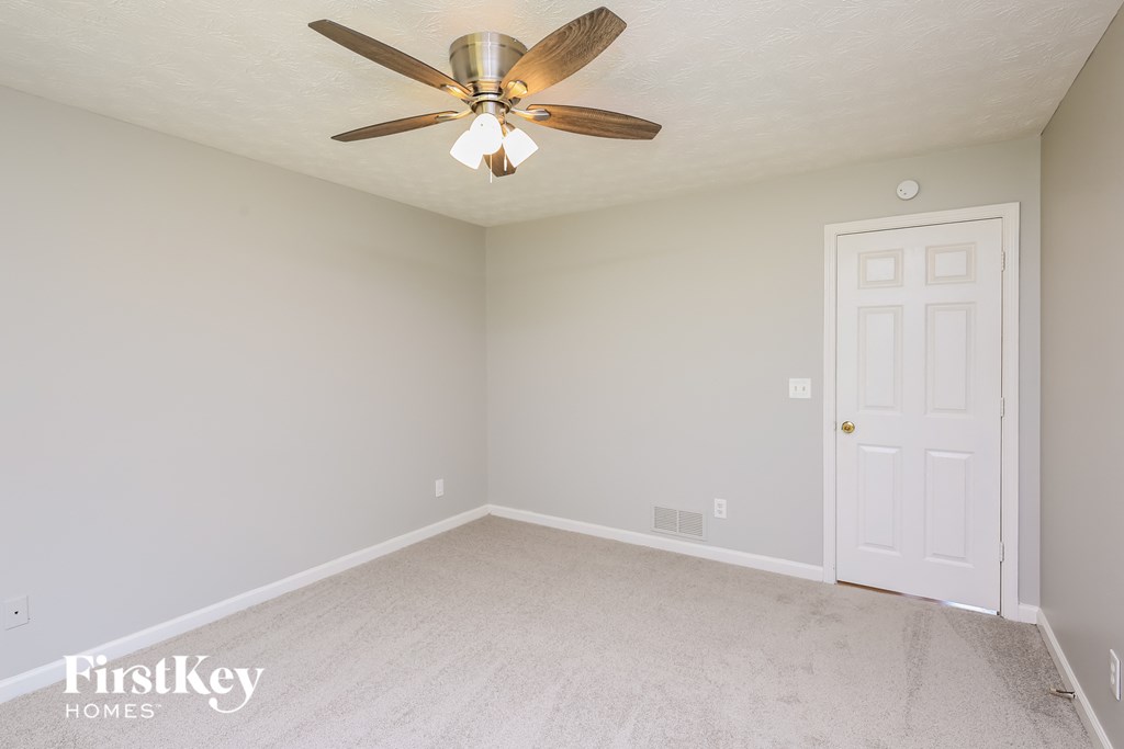 a bedroom with a ceiling fan and a white door