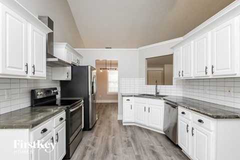 a kitchen with white cabinets and a black stove and refrigerator