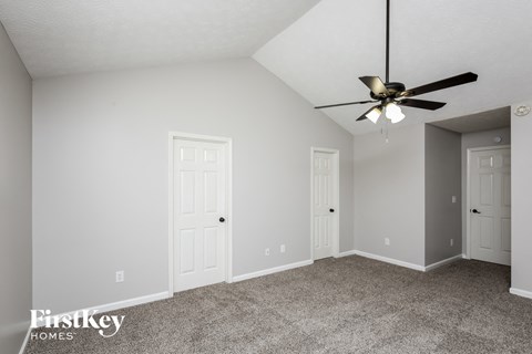 a bedroom with two doors and a ceiling fan