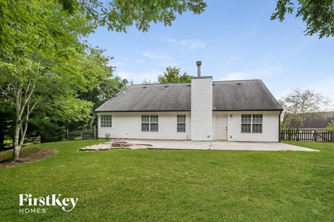 a white house with a grassy yard and a wood fence