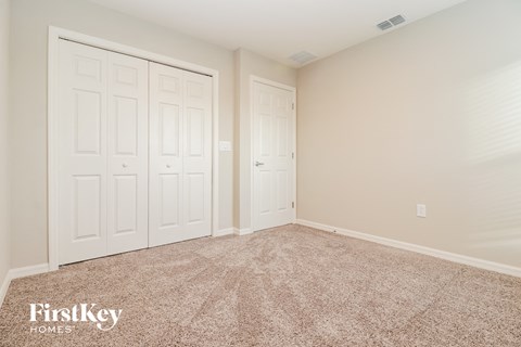 a bedroom with two closets and a carpeted floor