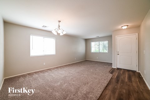 A room with a carpeted floor and a door is shown.