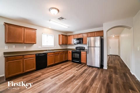 A kitchen with wooden cabinets and a refrigerator.