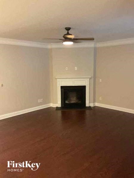 a living room with a fireplace and a ceiling fan