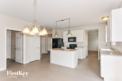 a large kitchen with white cabinets and a white counter top