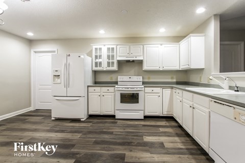 A kitchen with white appliances and cabinets.