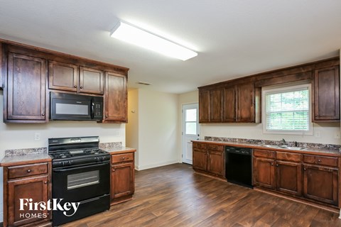 a kitchen with wooden cabinets and a stove and a microwave