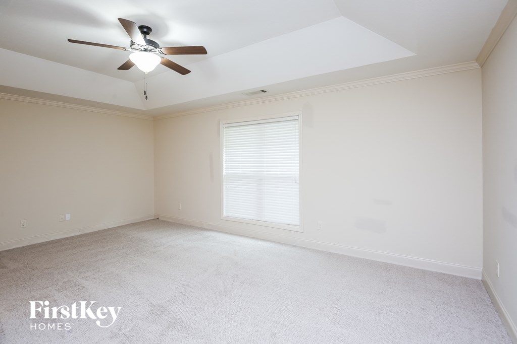 a white room with a ceiling fan and a window