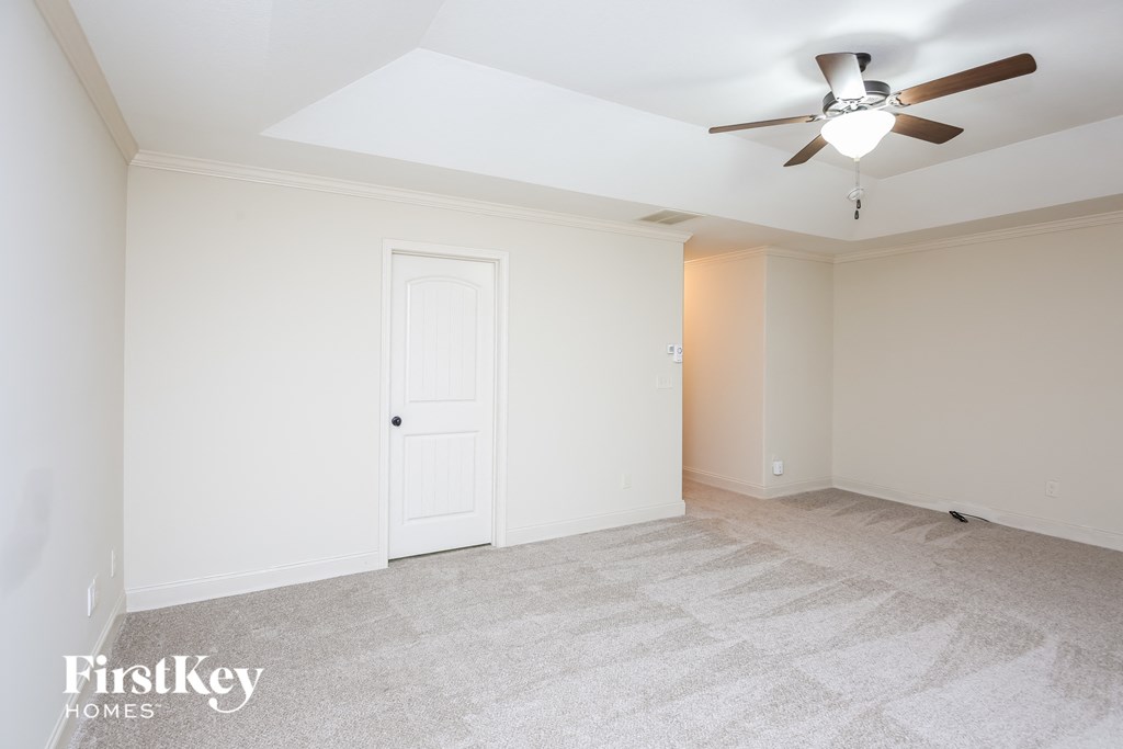 a living room with white walls and a ceiling fan