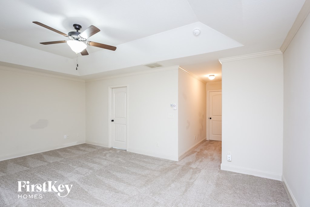 a living room with white walls and a ceiling fan