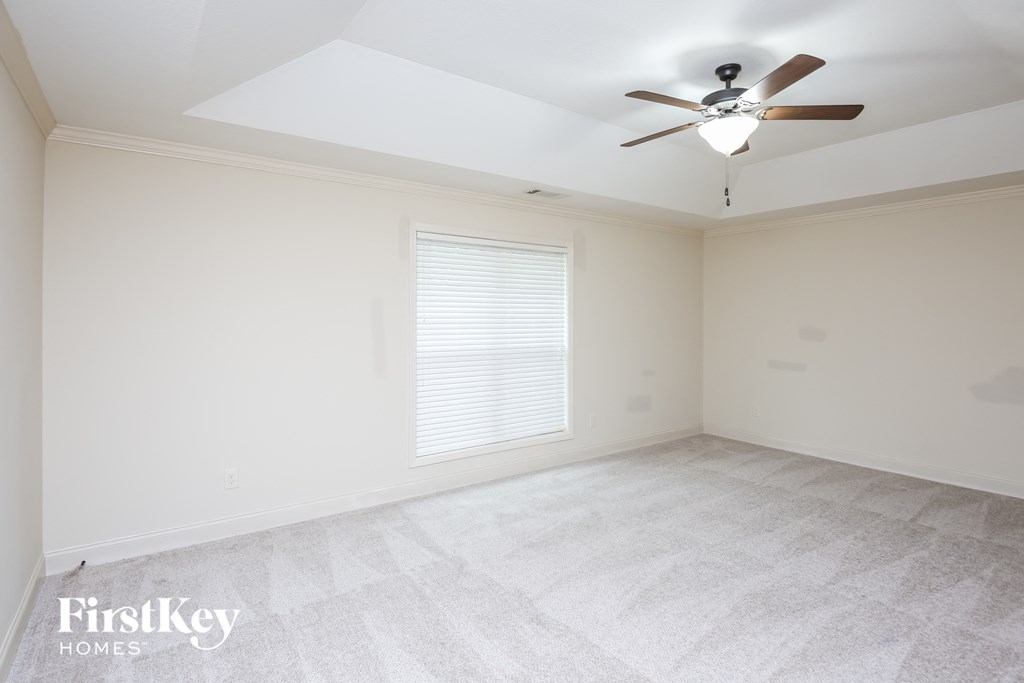 an empty room with a ceiling fan and a window