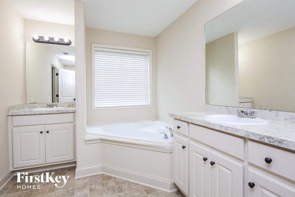 a bathroom with a tub and a sink and a mirror
