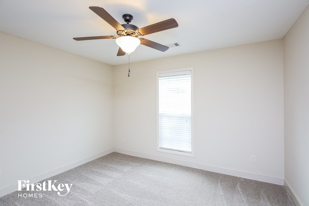a bedroom with a ceiling fan and a window