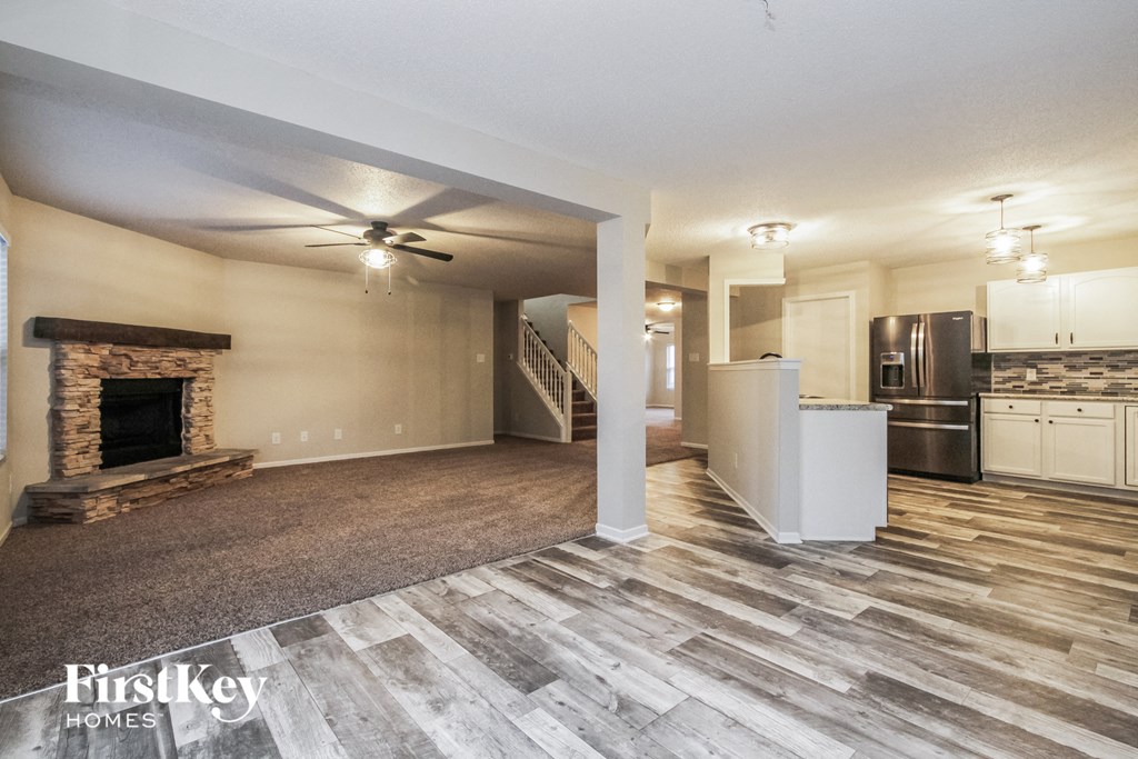 a living room with a fireplace and a kitchen