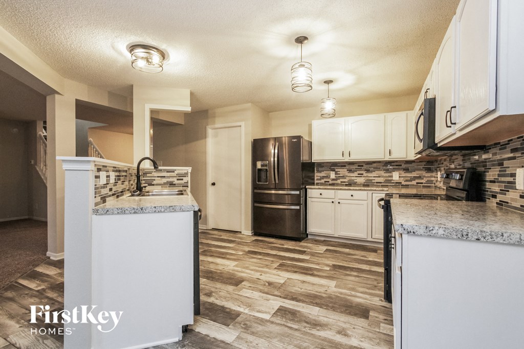 a kitchen with white cabinets and a stainless steel refrigerator
