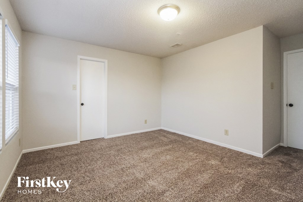an empty living room with carpet and white walls