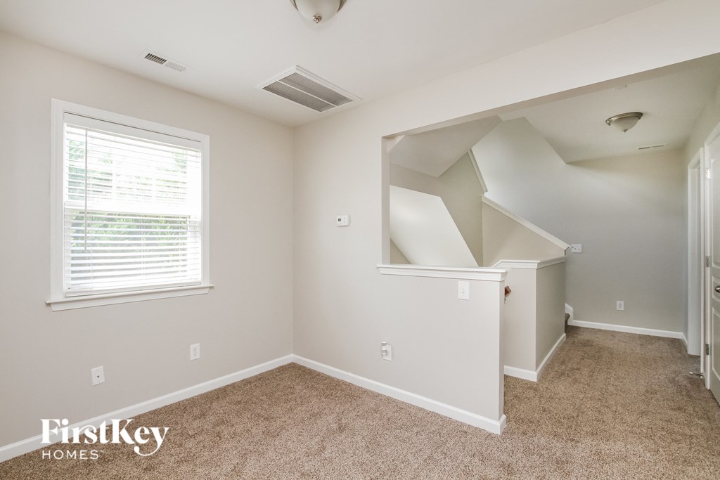 a bedroom with a large window and a carpeted floor
