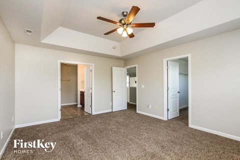 a living room with carpet and a ceiling fan