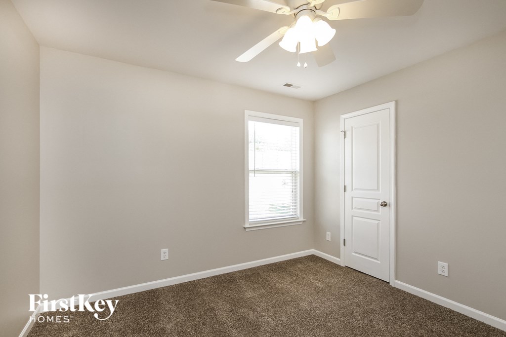 a bedroom with a ceiling fan and a white door