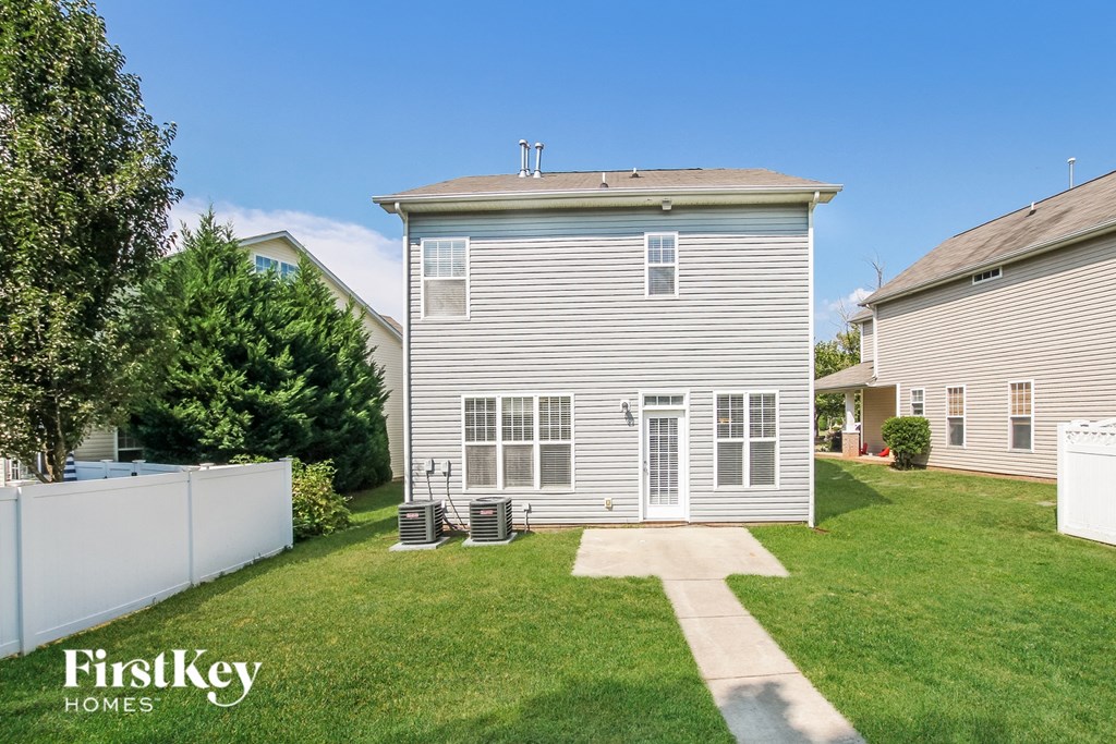 a white house with a yard and a white fence