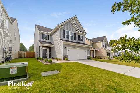 a white house with a lawn and a driveway