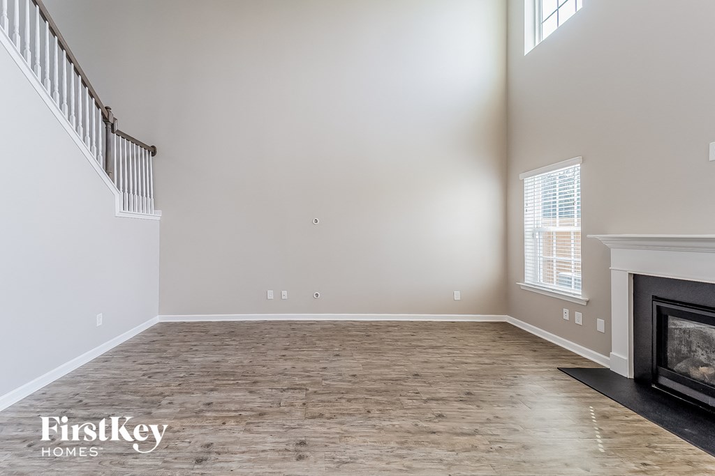 an empty living room with a fireplace and a staircase