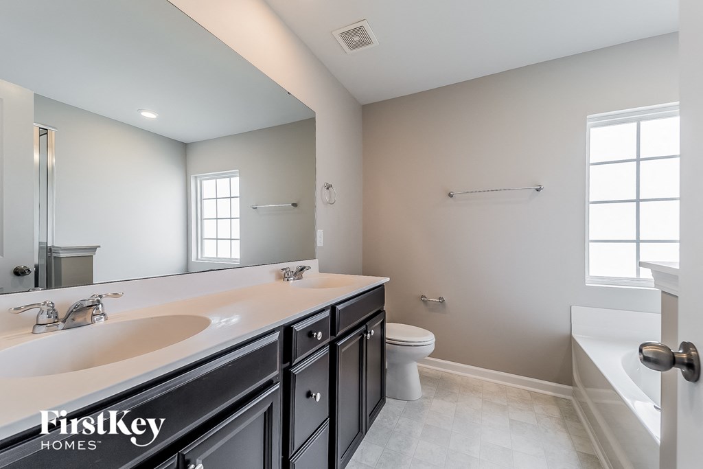 a bathroom with a large mirror and a sink and a toilet