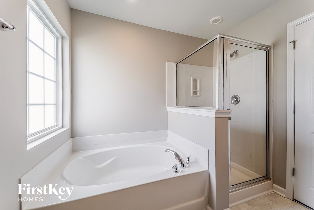 a white bathroom with a large tub and a shower