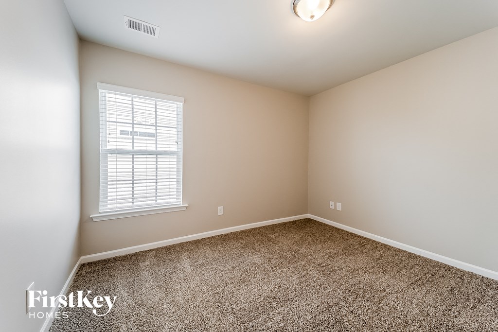 an empty room with carpet and a window