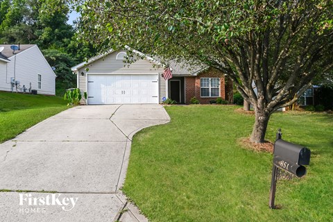 a house with a white garage door and a mailbox on the sidewalk