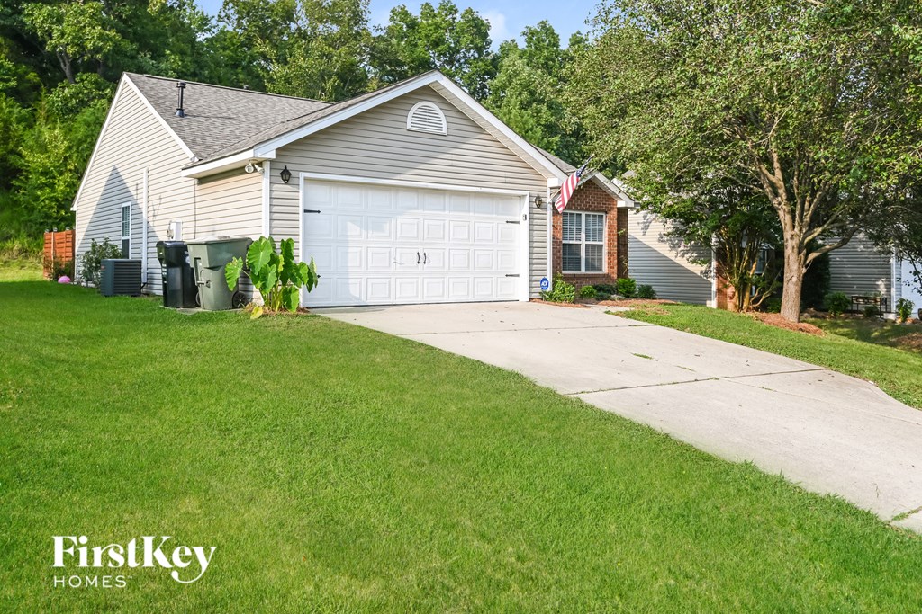 a white house with a white garage door and a driveway