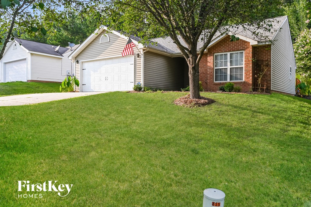 a lawn in front of a house with a tree