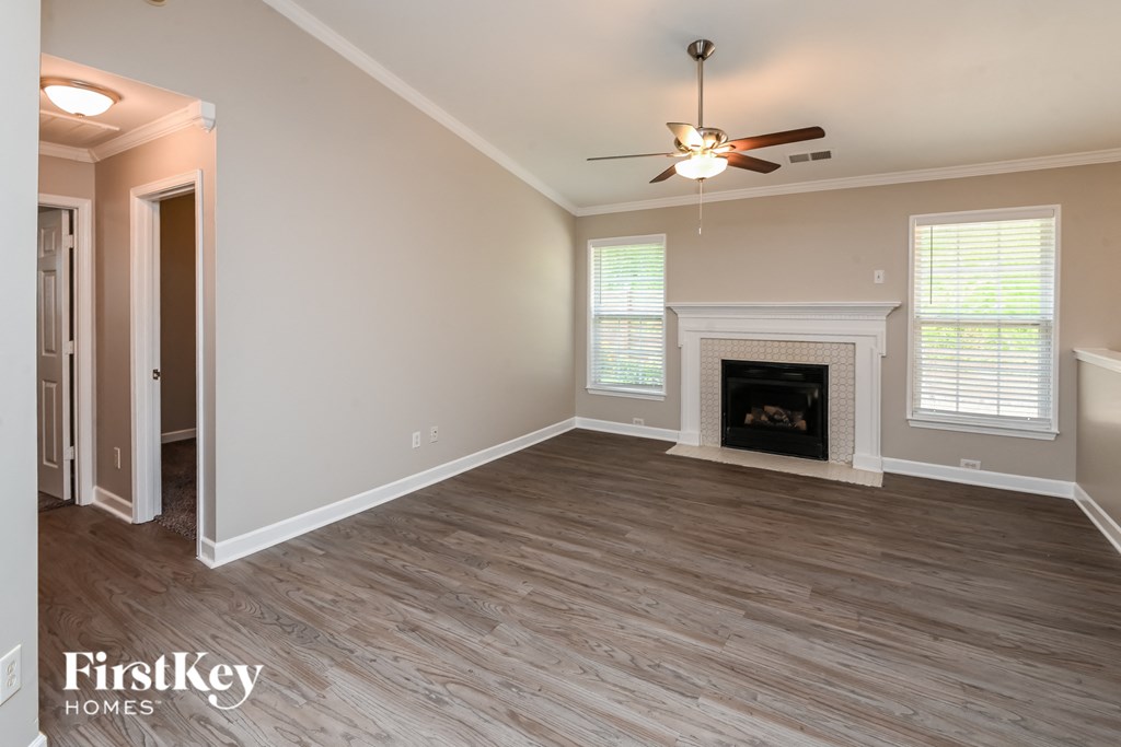 a living room with a fireplace and a ceiling fan