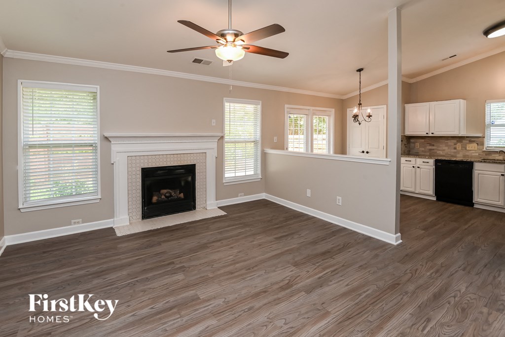 a living room with a fireplace and a ceiling fan