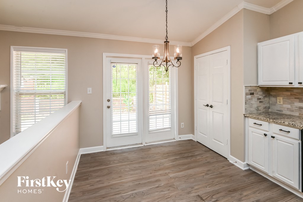 a kitchen and dining room with white cabinets and a wood floor