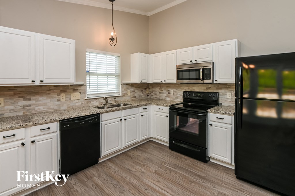a kitchen with black appliances and white cabinets