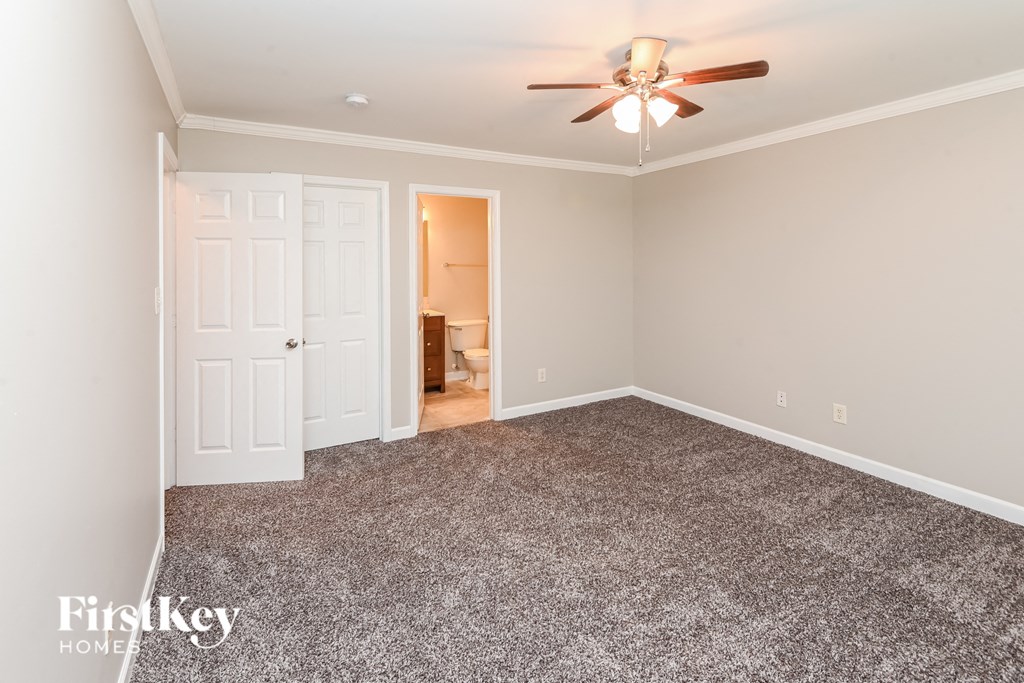 a bedroom with a carpeted floor and a ceiling fan