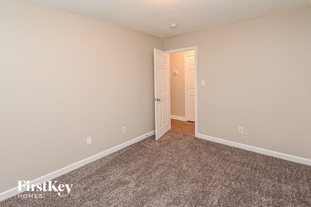 a bedroom with a carpeted floor and a door to a closet