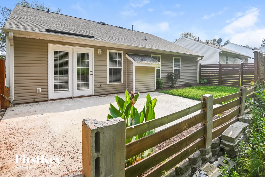 a house with a driveway and a fence in front of it