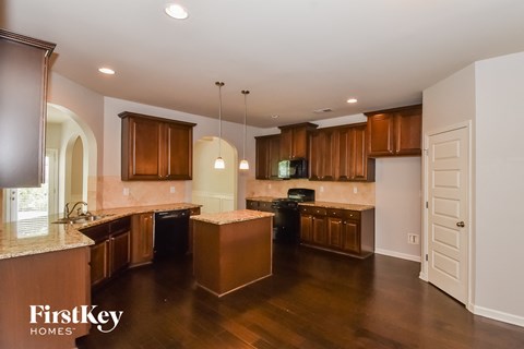 a large kitchen with wooden cabinets and counters and a wooden floor