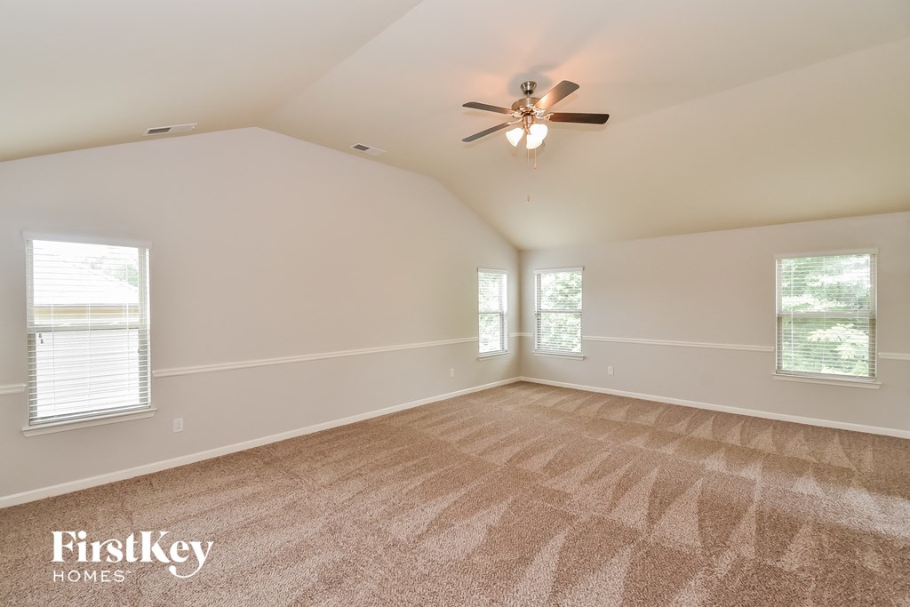 the master bedroom is spacious and clean with a ceiling fan