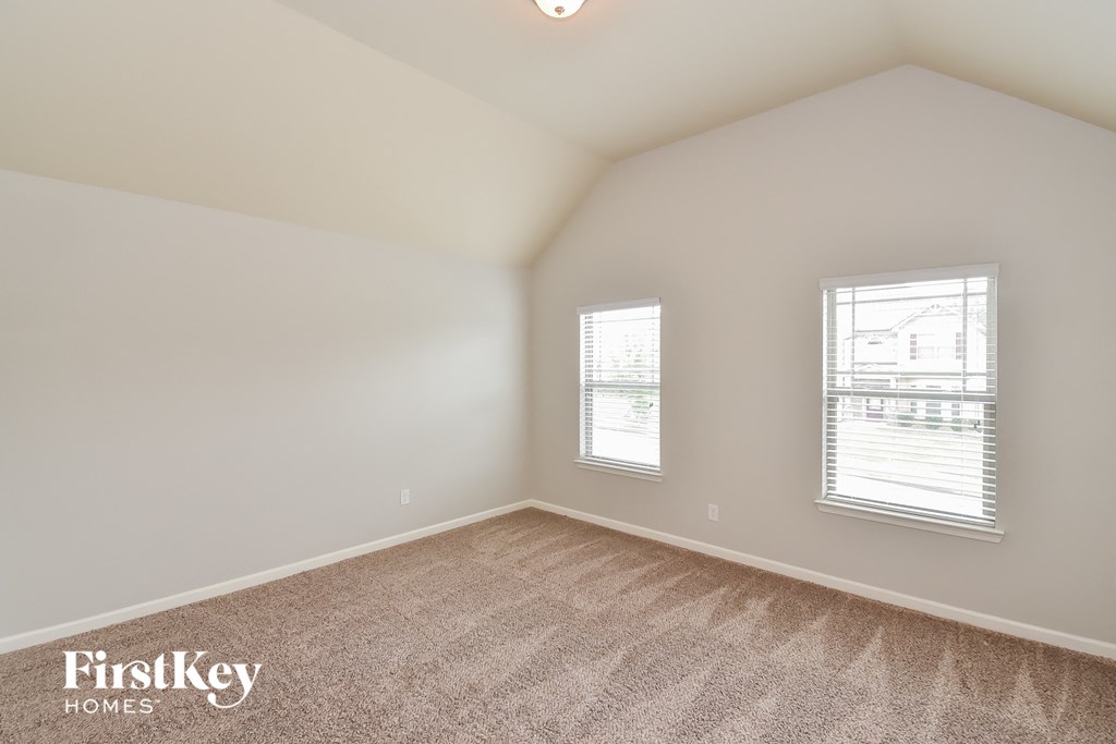 a bedroom with a carpeted floor and two windows