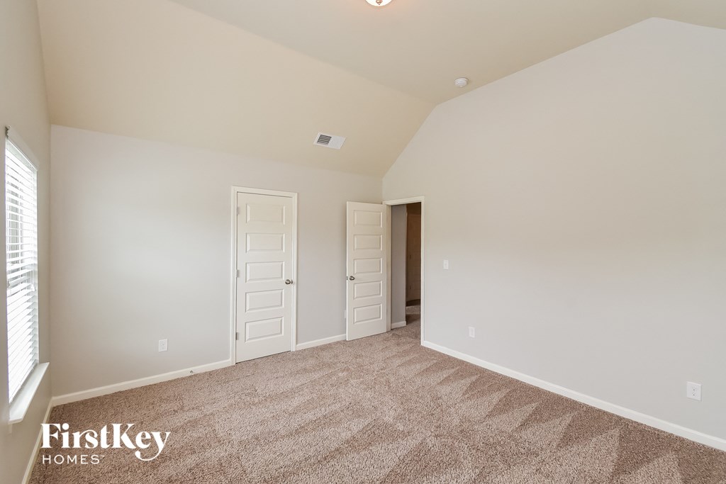 a bedroom with a carpeted floor and a door to a closet