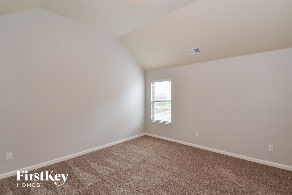 an empty room with carpet and a window