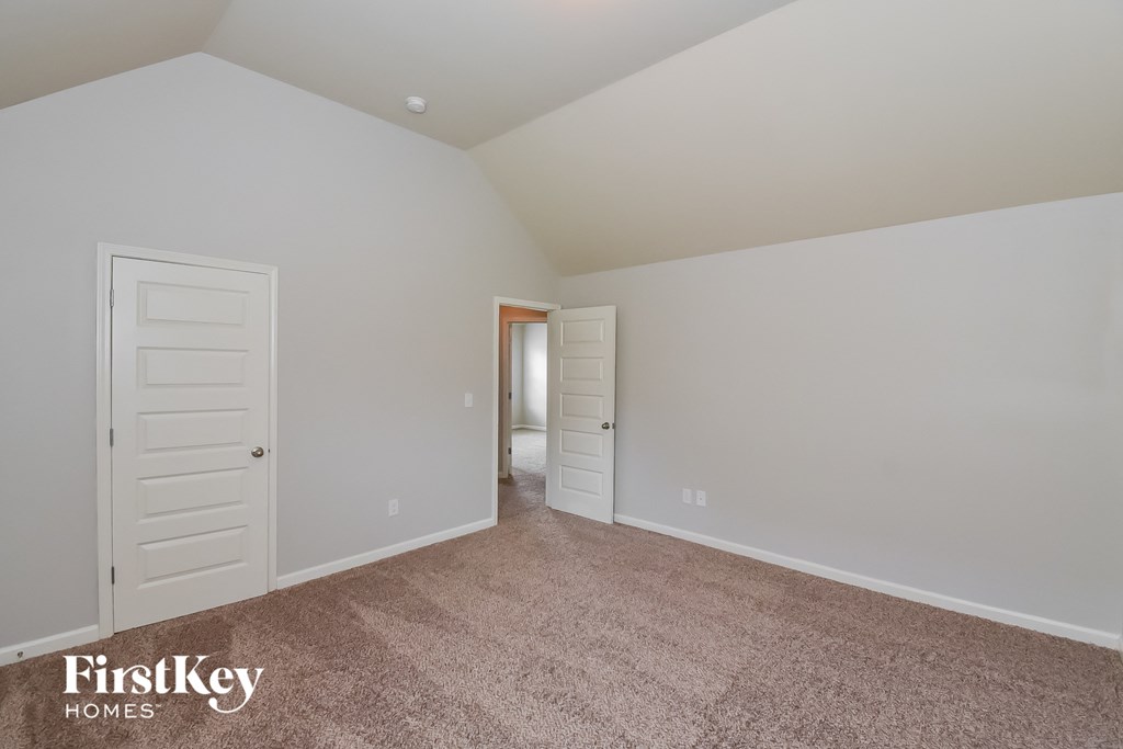 a master bedroom with carpet and a door to the bathroom